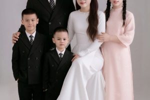 Ảnh chụp gia đình kỷ niệm 11 năm ngày cưới với trang phục áo dài và vest sang trọng tại studio.