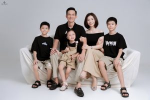 Ảnh chụp gia đình với trang phục tông màu đen và be đồng bộ trong studio.